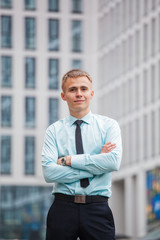 guy in business style clothes on the background of a tall building