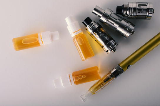 isolated vape tanks and e liquid for electronic cigarette or e cig over a white background. vaping rdta and e juice for vaping devices.