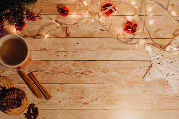 top view of Christmas and new year decorations on wooden desk with lights and free space for your text