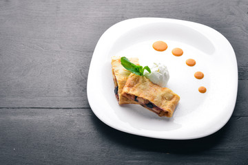 Apple Strudel with Ice Cream. On a wooden background. Top view. Free space for your text.