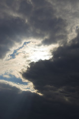 the light of the sun through dark clouds