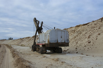 old abandoned gray digger in a sandpit