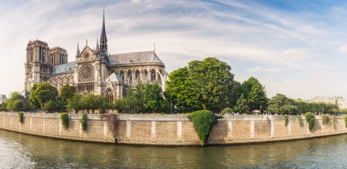 Naklejka premium Notre Dame de Paris, France, at daytime. Summer travel background. Scenic cityscape with dramatic sky.