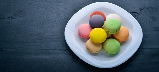 Obraz na płótnie Canvas Colorful macarons cakes. On a wooden background. Top view. Free space for your text.