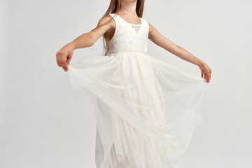 little ballerina in a light dress demonstrates her hands