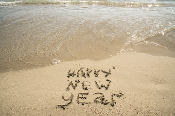 Happy new year written on sandy beach, New Year 2018 is coming concept.