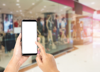 Hand holding smartphone on shopping mall background blurred, Hand touching screen