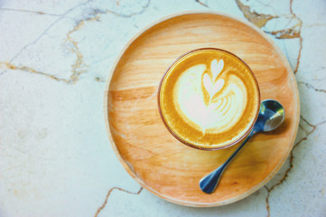 Coffee cup on wooden plate with marble table background 