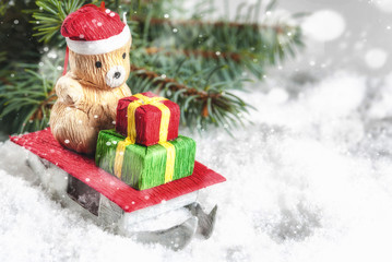 Christmas tree toy, little bear looked like santa claus,on sledges. Merry Christmas greeting card with snow background. Copy space