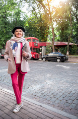 Happy old woman in fashionable clothing on street