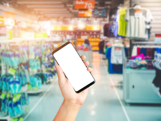 Hand holding smartphone on sport department store background blurred, Shopping centre mall