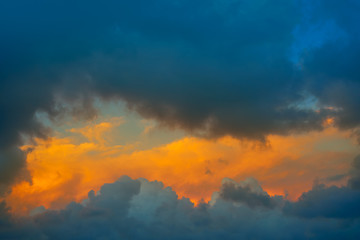 Dramatic clouds at sunset orange sky