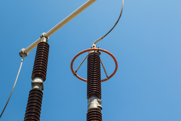 Power substation detail, red high voltage isolation over blue sky