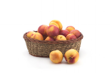 Ripe nectarines small, lying in a wicker basket - 177910625