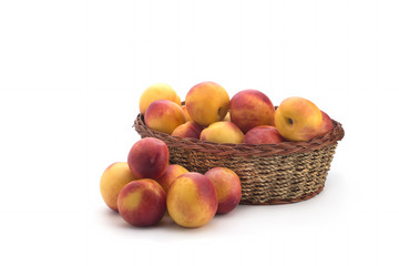 Basket full of fresh peaches isolated on white background