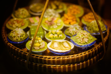 close up Miniature clay figurine Thailand's floating market,Miniature boat carrying tropical fruit on wood background