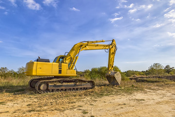 Fototapeta na wymiar A stopping yellow excavator after work