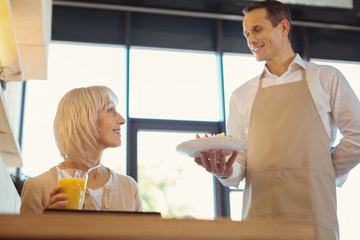 Positive delighted woman looking at the salad
