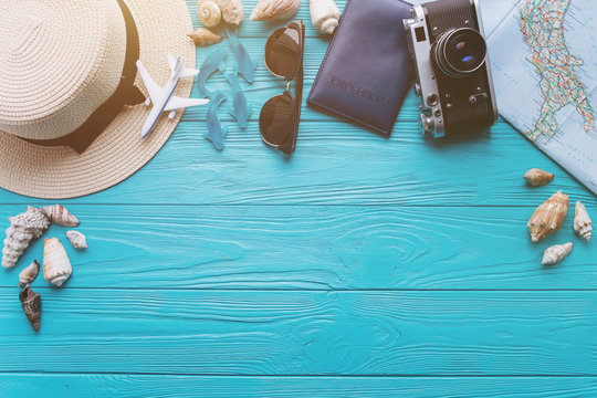 Top view of beach summer accessories with copy space. Lay flat holiday fashion background on blue wooden table or floor.Travel concept.