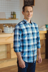 Obraz premium Pleasant good looking man standing in the kitchen