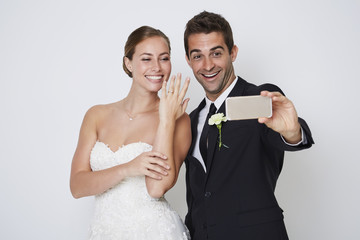 Happy couple posing for selfie, studio