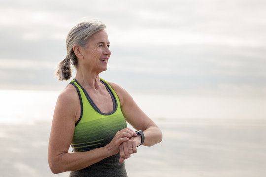 Senior woman setting watch before a run