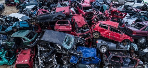 Old rusty corroded cars in car scrapyard.