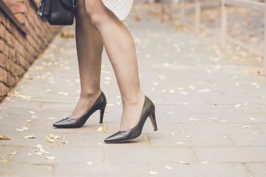Woman legs wearing black high heel shoes