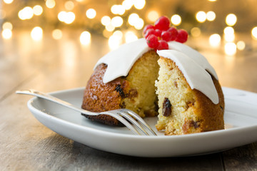 Christmas pudding and christmas light on wooden table
