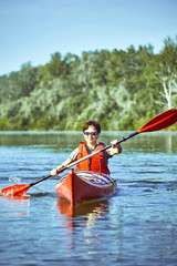 A canoe trip along the river along the forest in summer.