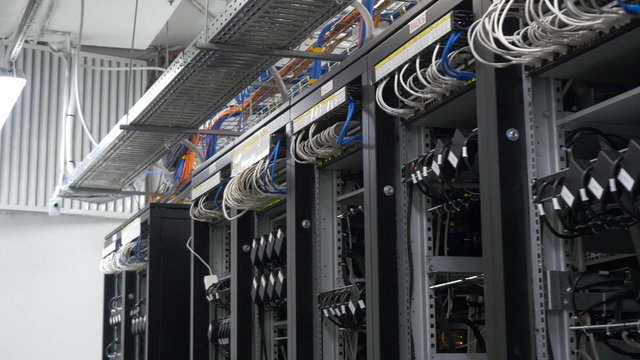Device for mining crypto currency. Row of bitcoin miners set up on the wired shelfs. Mining cryptocurrency. Bitcoin farm. Machines for mining cryptocurrency, bitcoin. Electronic device at day