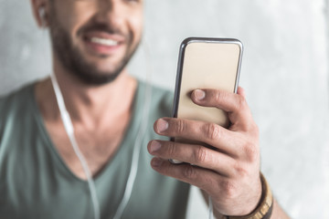 Cheerful cute guy is using his mobile phone