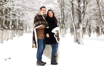 Fototapeta na wymiar A young couple walk in a winter park