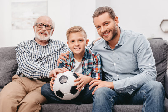 Family sitting on couch with soccer ball