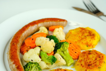 Bratwurst mit Gemüse und Kartoffelplätzchen