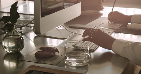 mixed race businessman working with computer. White shirt, smartphone