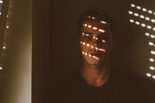 Portrait of a Young Man in Dark with Sunlight Dots on His Face