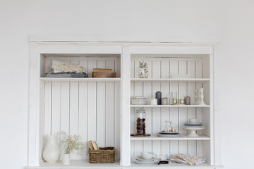 White wooden closet with different decorative items.