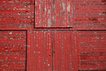 graphic close up photo of old red wooden barn patina doors in the country