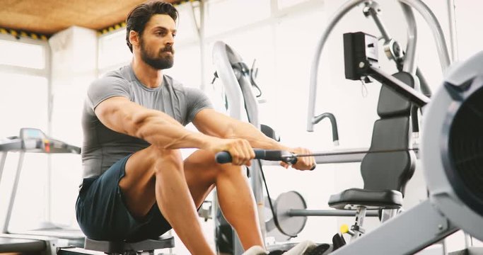 Young handsome man doing exercises in gym