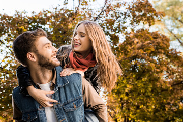Fototapeta premium couple piggybacking in autumn park