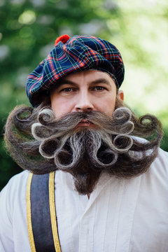 Handsome portrait of a brave Scot with a amazing beard and mustache curls in the Hungarian style.