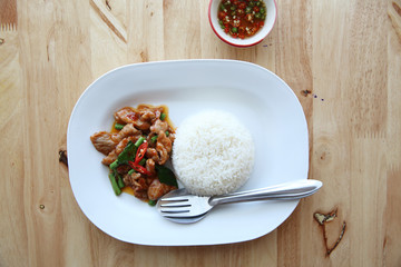 fried pork with thai curry and rice on wood background , Thai food