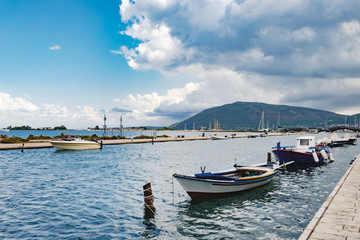 Traditional fishing boats on the waterfront of Lefkada city under a cloudy sky. Lefkada or Lefkas is a Greek island in the Ionian Sea on the west coast of Greece