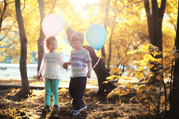 Little children are walking in autumn park