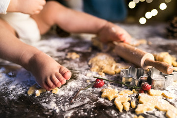 Young family making gingerbread cookies at home.
