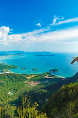 View of blue sky, sea and ski cable car seen from Cable Car viewpoint, Langkawi, Malaysia. Picturesque landscape with town among tropical forest, beaches, small Islands in waters of Strait of Malacca