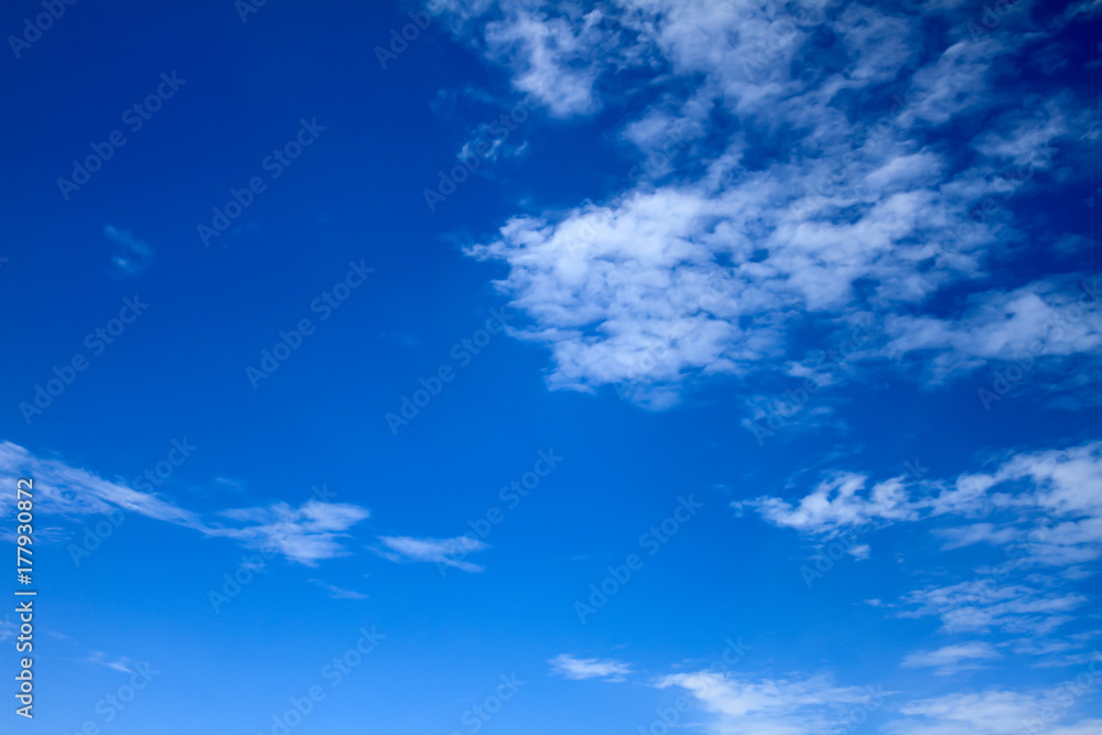 Wall mural background - vivid and bright blue sky with white dispersed clouds