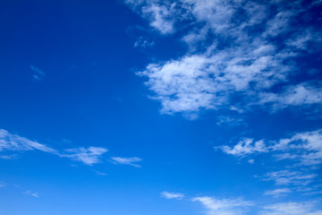 Naklejka na ściany i meble Background - Vivid and bright blue sky with white dispersed clouds