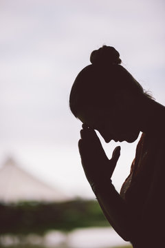 silhouette of peaceful woman in prayer position